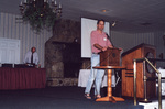 Jim Cox leans casually against a podium at a Florida Ornithological Society meeting in Fort Pierce, Florida