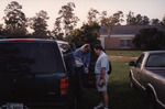 Two Guests Refill Water Bottle from Gallon Jug Outside Tall Timbers Research Station by Florida Ornithological Society