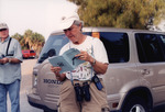 Ed Slaney Looks on as Lyn Atherton Consults Information Pamphlet for Birding Trip in St. Petersburg by Florida Ornithological Society