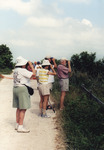 Jack Hail Peers Through Binoculars Beside Birding Group in Marathon, Florida by Florida Ornithological Society