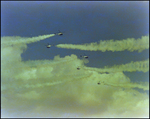 Six helicopters trail green smoke through the sky during a air show in Tampa, Florida
