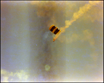 A professional parachuter descends from the sky while trailing yellow smoke during a air show in Tampa, Florida
