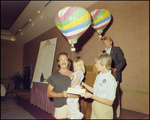 A man receives an award while holding a young girl at the Harbour Island Balloon Regatta in Tampa, Florida