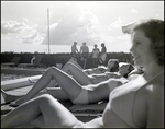 Four women lay in the sun while four others chat behind them at Bay Pointe Condominiums in Tampa, Florida