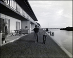 A couple holds hands by the water at Bay Pointe Condominiums in Tampa, Florida, A