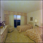 A pink bedroom with two twin beds at Bay Cove Apartments in Clearwater, Florida