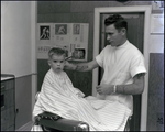 A young Doug Belden receives a haircut in Tampa, Florida, B