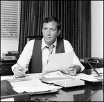 Jerry Bowmer Posing with Papers at his Desk, B by Skip Gandy