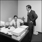 Jerry Bowmer Looking over Courthouse Employee's Desk by Skip Gandy