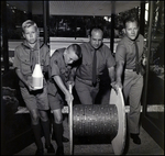 Boys Scouts and Boy Scout Leaders Roll a Wooden Spool of Cord Made of Pennies, B by Skip Gandy