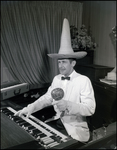 Musician Wearing a Sombrero and Holding a Maraca While Playing the Piano by Skip Gandy