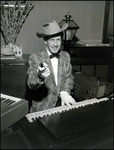 Musician Pointing a Prop Gun While Playing the Piano by Skip Gandy