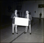 Two Adults Hold up an Ornamental Check at Berkeley Preparatory School in Tampa, Florida, B by Skip Gandy