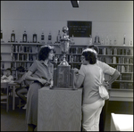 The Adults Chat Over a Bookcase Holding a Large Trophy at Berkeley Preparatory School in Tampa, Florida, A by Skip Gandy