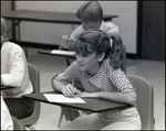 A Girl Writes on a Sheet of Notebook Paper in Class at Berkeley Preparatory School in Tampa, Florida by Skip Gandy