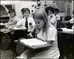 A Girl Smiles While Reading in Class at Berkeley Preparatory School in Tampa, Florida by Skip Gandy