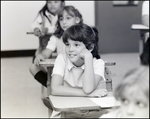 A Girl Smiles While Propping Her Chin up on Her Desk at Berkeley Preparatory School in Tampa, Florida by Skip Gandy