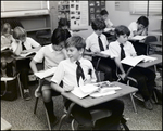 A Boy Glances at a Friend While Reading in Class at Berkeley Preparatory School in Tampa, Florida