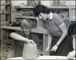 A Student Shows His Teacher an Unfinished Piece of Pottery at Berkeley Preparatory School in Tampa, Florida, A by Skip Gandy