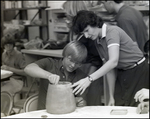 A Student Shows His Teacher an Unfinished Piece of Pottery at Berkeley Preparatory School in Tampa, Florida, B by Skip Gandy