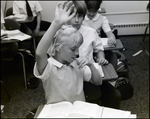 A Girl Raises Her Hand While Biting Her Nails at Berkeley Preparatory School in Tampa, Florida by Skip Gandy