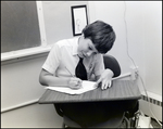 A Boy Smiles While Writing at His Desk at Berkeley Preparatory School in Tampa, Florida