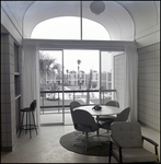 A Small Dining Room Overlooks a Pool and Courtyard at Beverly Apartments in Tampa, Florida, B by Skip Gandy