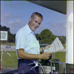 A Man on a Bicycle Smiles With a Copy of the St. Petersburg Times in Beverly Hills, Florida, A by Skip Gandy