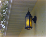 A Wall Sconce Decorates the Outdoor Wall of a Home Underneath the Awning in Beverly Hills, Florida, A by Skip Gandy