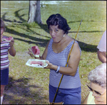 Woman Eats Watermelon With a Fishing Rod Under Her Arm in Beverly Hills, Florida by Skip Gandy