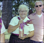 Woman Holds Wrapped Gift at German American Social Club Festival in Beverly Hills, Florida, B by Skip Gandy