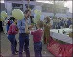 Man Helps Child Tie Balloon at Burnt Store Marina Seafood Festival in Punta Gorda, Florida by Skip Gandy