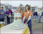 Two Women Hold Tiered Cake at Burnt Store Marina Seafood Festival in Punta Gorda, Florida, E by Skip Gandy