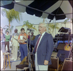 Man in Blue Jacket Addresses Crowd at Burnt Store Marina Seafood Festival in Punta Gorda, Florida by Skip Gandy