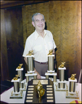 Man Smiling in Front of Table of Trophies, Burnt Store Marina Seafood Festival, Punta Gorda, Florida, B by Skip Gandy