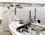 Man Walking Around Prow of a Sailboat at Davis Islands Yacht Club, Tampa, Florida by George Skip Gandy IV