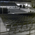 Empty Stadium Seats in Front of People Setting Up Ice Rink, Tampa, Florida by George Skip Gandy IV