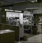 Woman Standing in Kelvin and Hughes Exhibit Booth, Tampa, Florida by George Skip Gandy IV