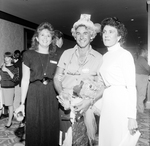 A Man Holding a Stuffed Animal Posing with Two Women by George Skip Gandy IV