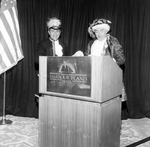 Two Men in Period Costumes Speak from a Podium by George Skip Gandy IV