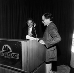 A Man Approaches a Podium While Another Man Applauds by George Skip Gandy IV