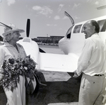 Women with Flowers and Jack Eckerd next to Plane by George Skip Gandy IV