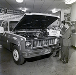 Vernon Krutsinger and Unknown Man Inspect Chevrolet Display for LP-Gas, Dancey Co, E by George Skip Gandy IV