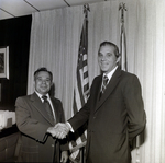 Handshake Between Two Businessmen in Front of Flags, C by George Skip Gandy IV