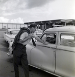 Man Engaging with a Vehicle at a Parking Lot, A by George Skip Gandy IV