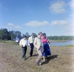 Businesspeople Walk by Helicopter in Field for M-C Development, C by George Skip Gandy IV