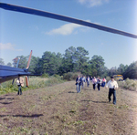 Businesspeople Walk by Helicopter in Field for M-C Development, D by George Skip Gandy IV