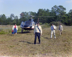 Businesspeople Walk by Helicopter in Field for M-C Development, E by George Skip Gandy IV