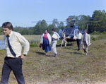 Businesspeople Walk by Helicopter in Field for M-C Development, F by George Skip Gandy IV