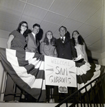 Men and Women with 'Welcome Sam Gibbons' Sign for Master Charge, A by George Skip Gandy IV